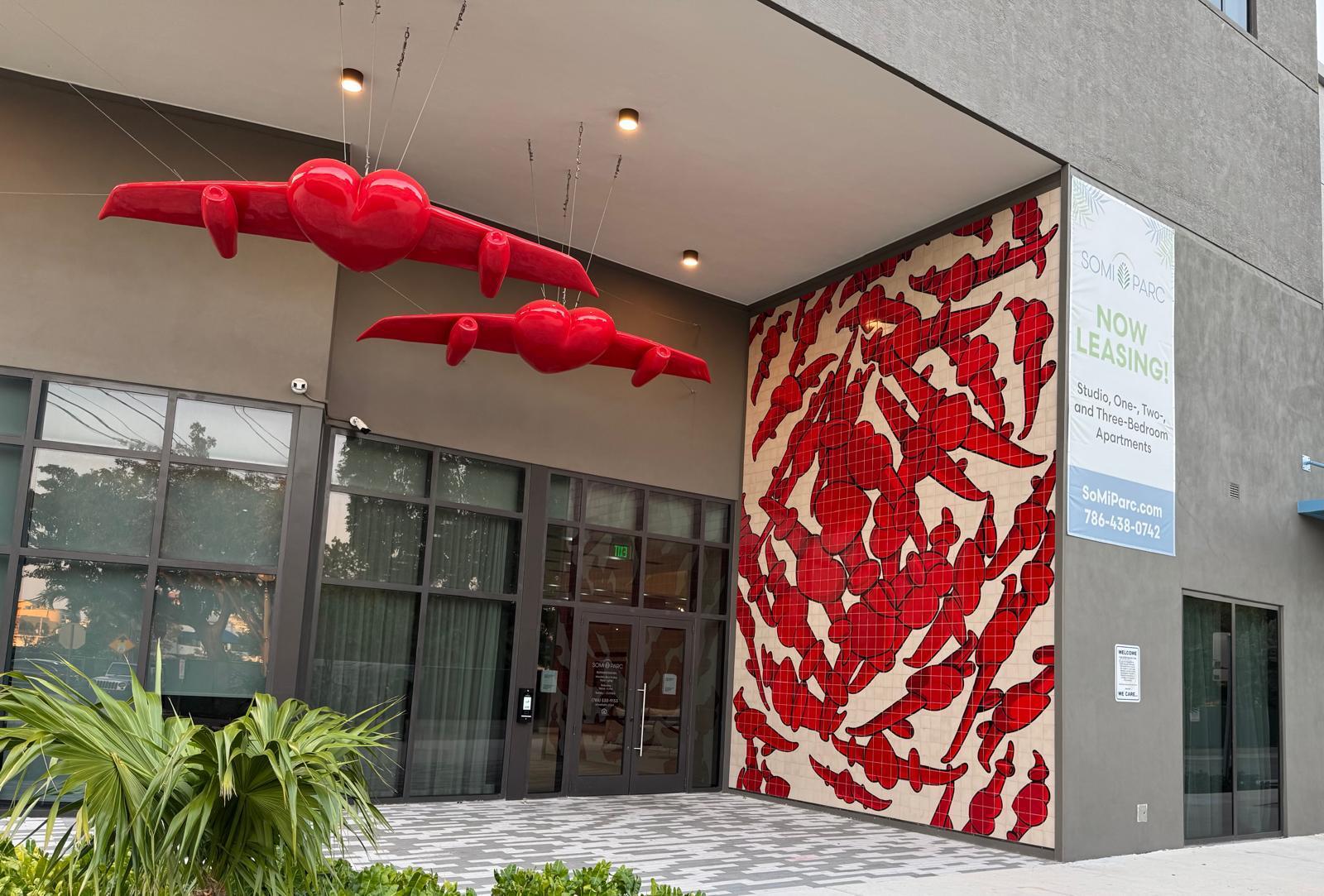 Daytime view of the completed installation at the SoMi Parc entrance, with a 'Now Leasing' sign beside the tile mural.