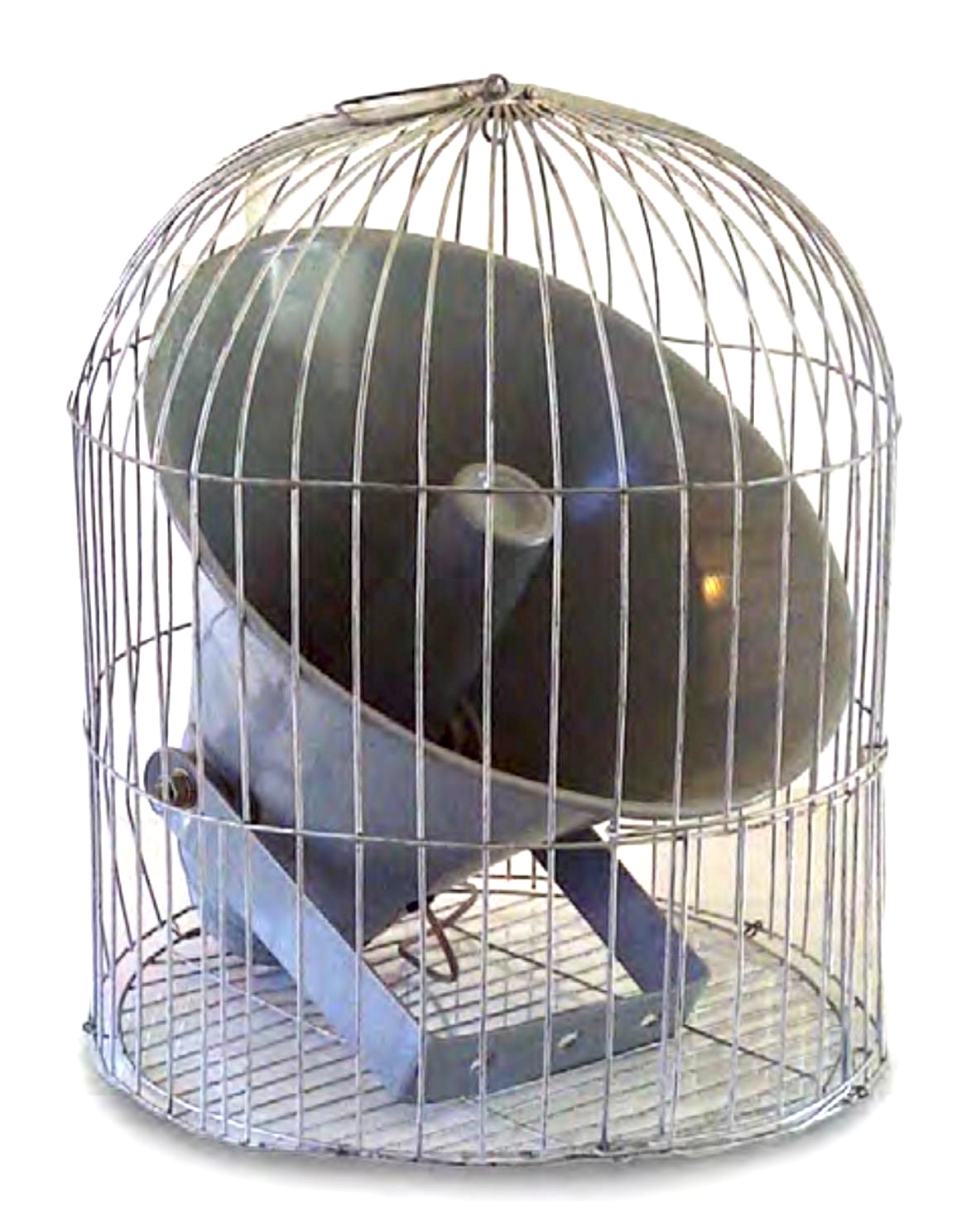 A tall dome-shaped wire birdcage on casters, containing a large glossy dark green egg- or helmet-shaped form tilted on an angled metal stand.